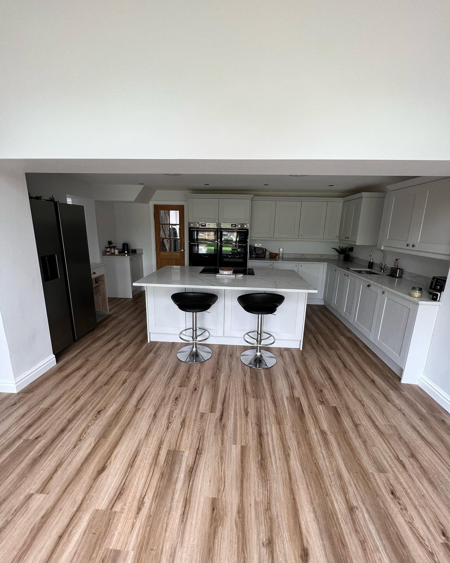 Painted Shaker kitchen with integrated appliances and herringbone floor