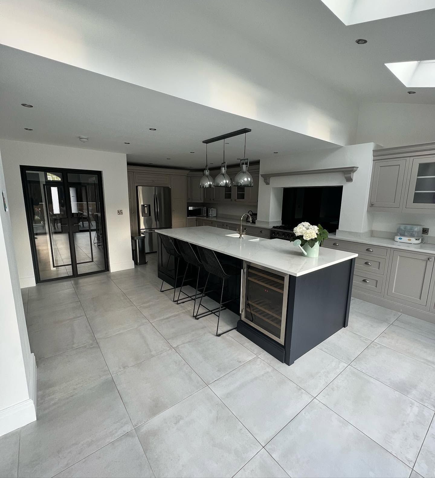 Large fitted kitchen with island, range cooker and pendant lighting