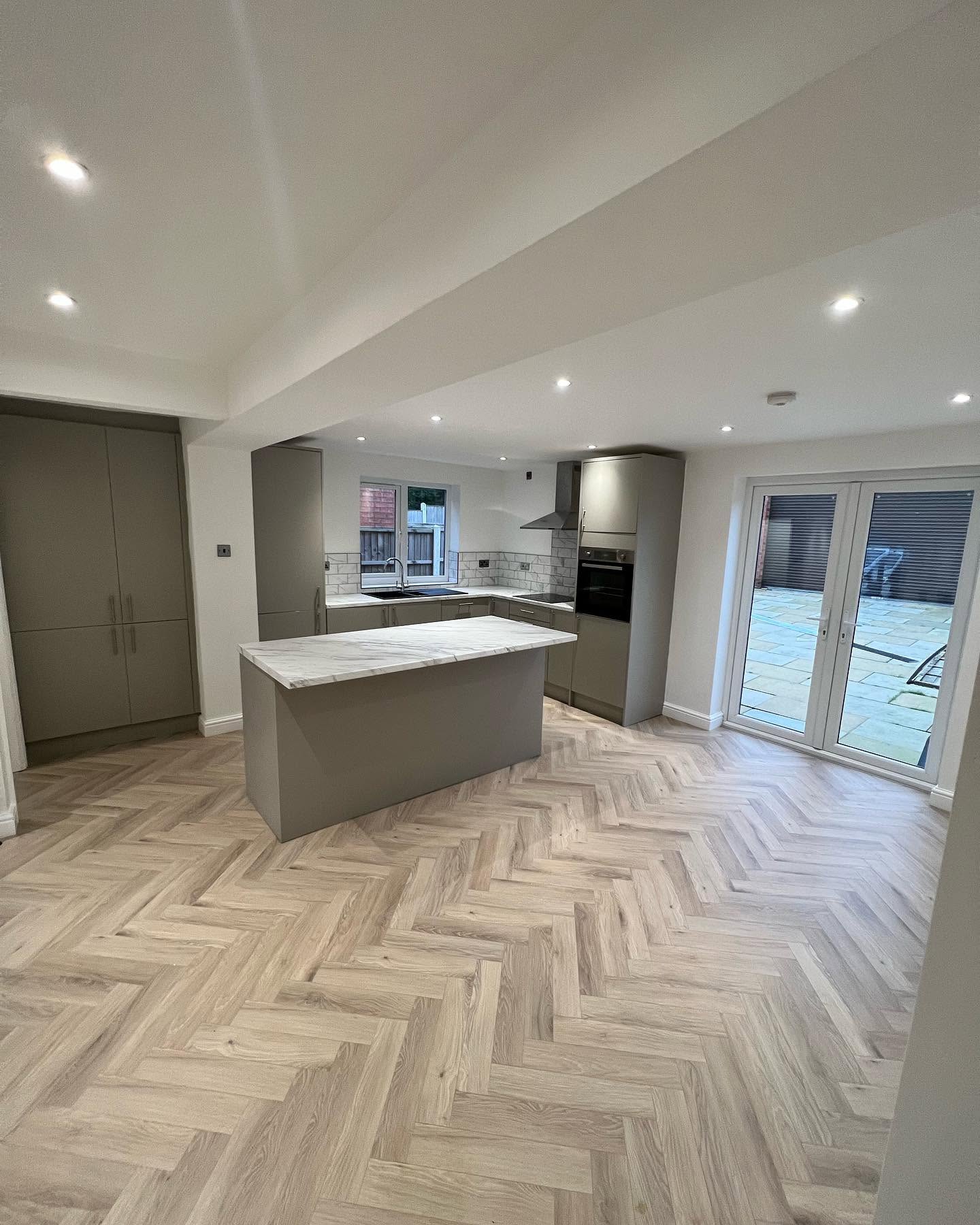 Open-plan kitchen extension with herringbone floor and bifold doors