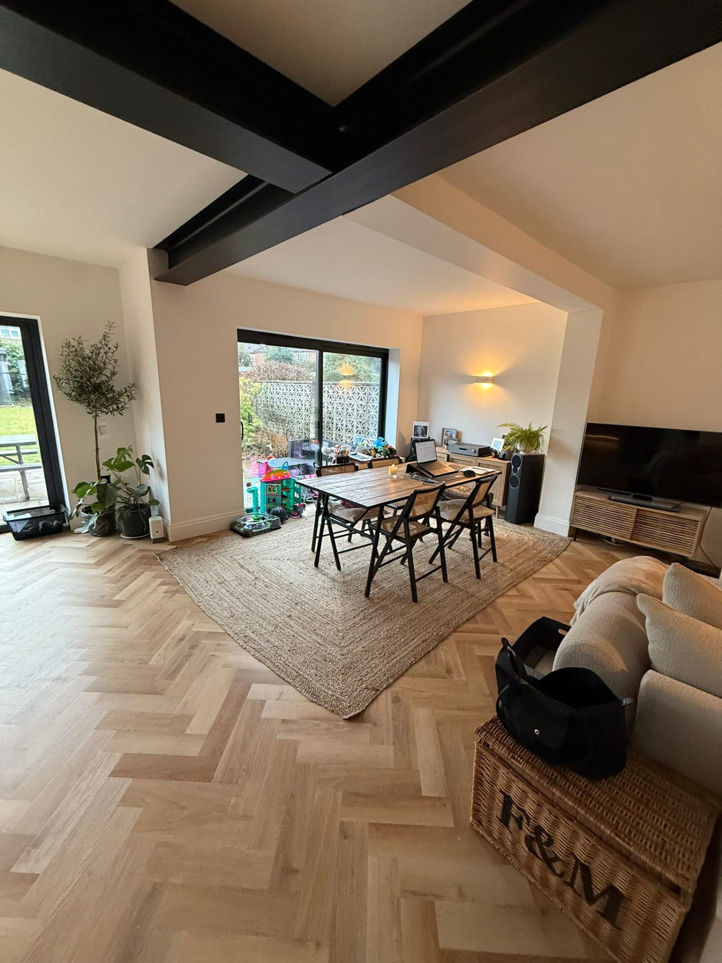 Bright dining area inside a completed rear extension with steel beam feature ceiling