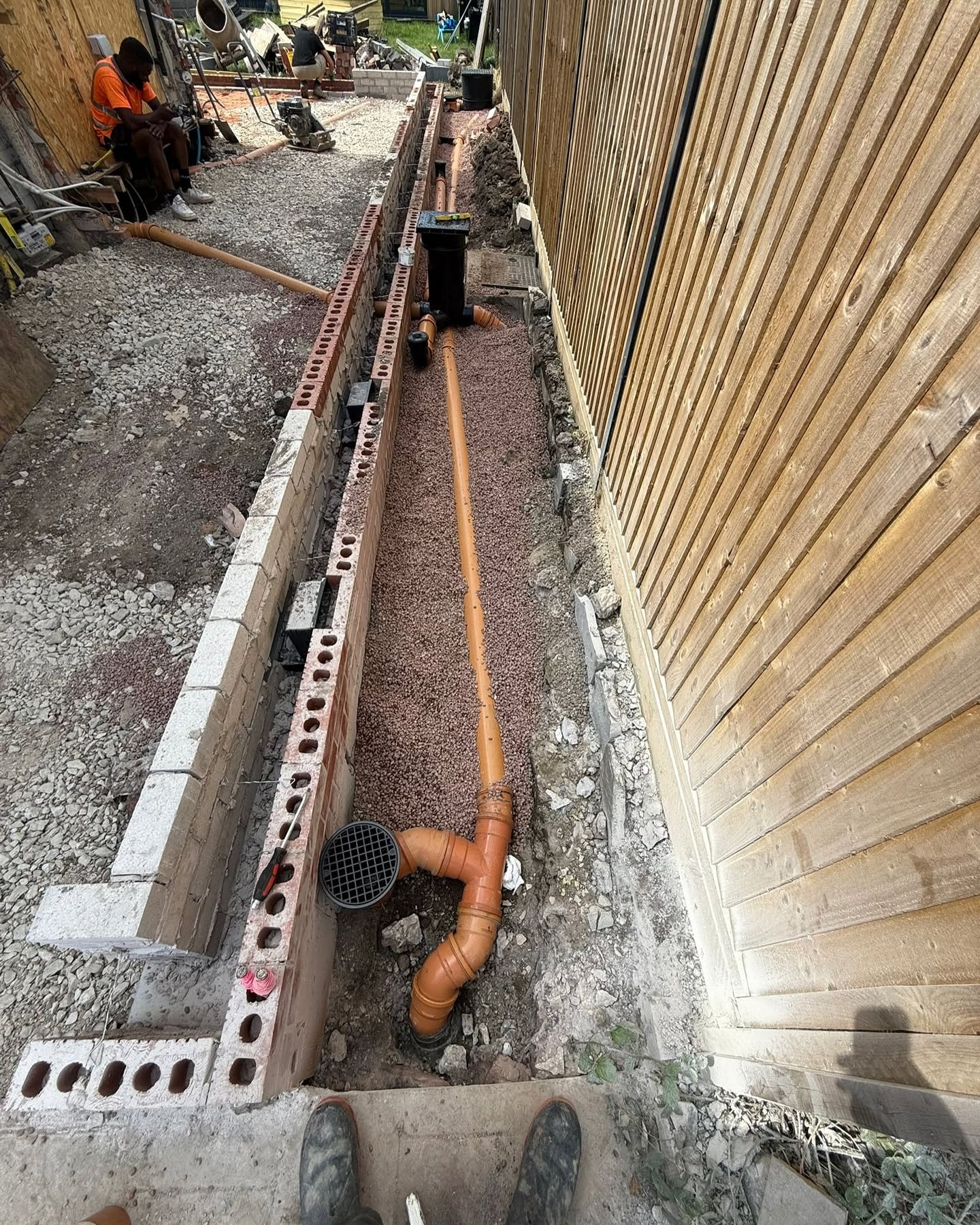 Underground drainage installation in trench beside new extension