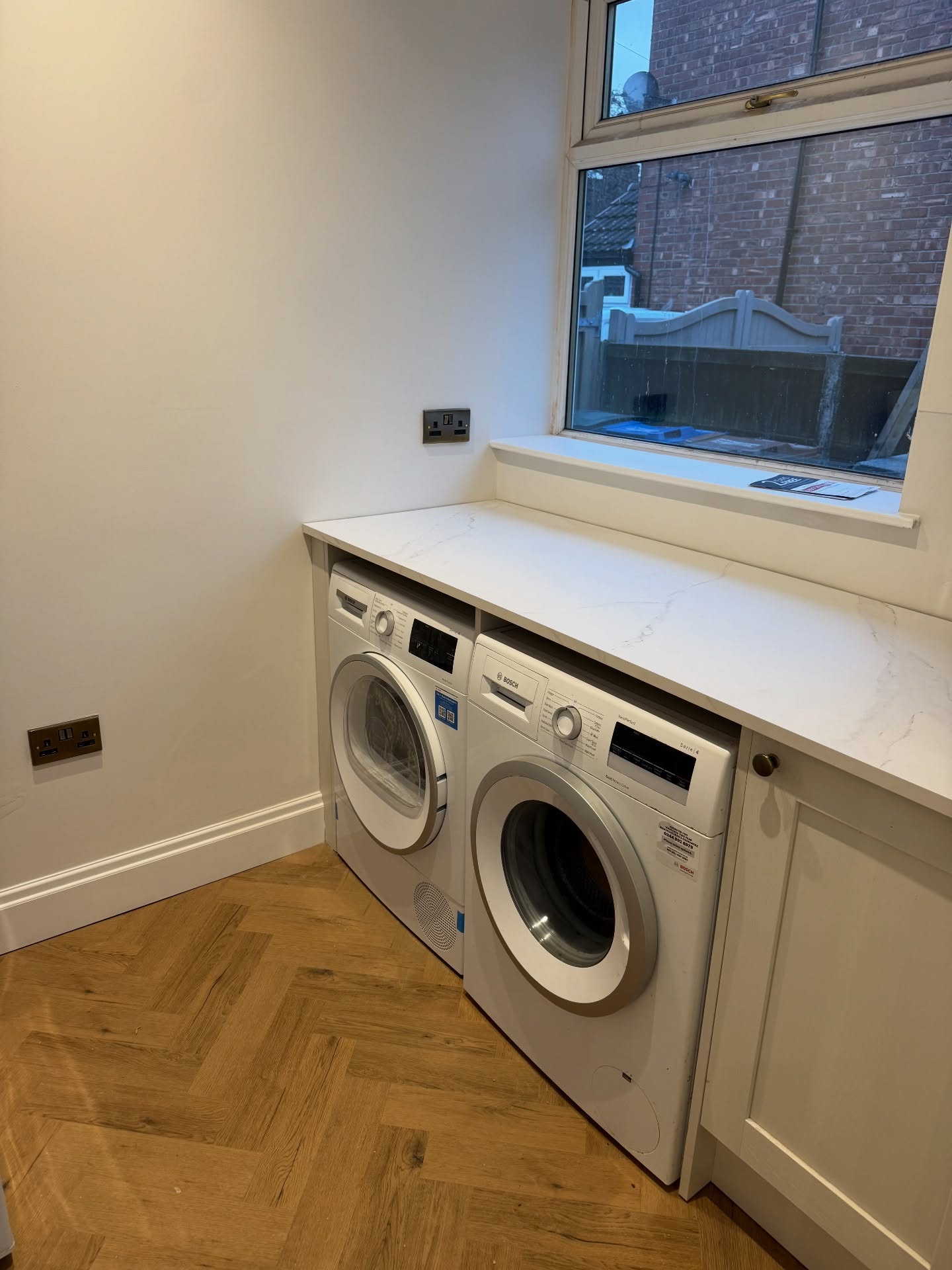 Bespoke utility room with integrated washer-dryer and herringbone floor