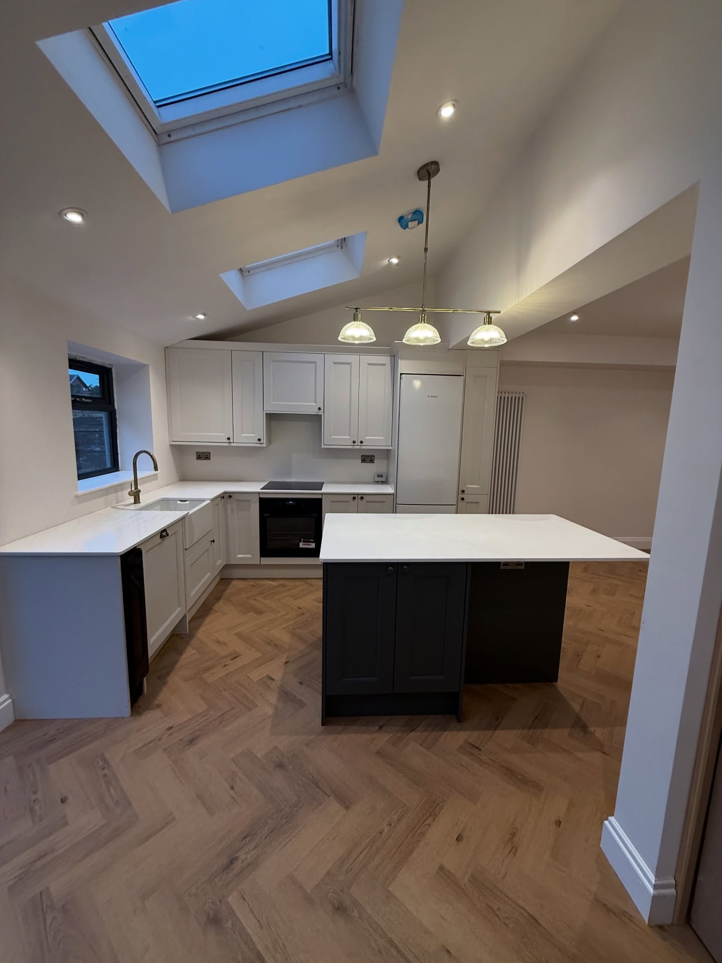 Open-plan kitchen-diner with two-tone island and roof lanterns