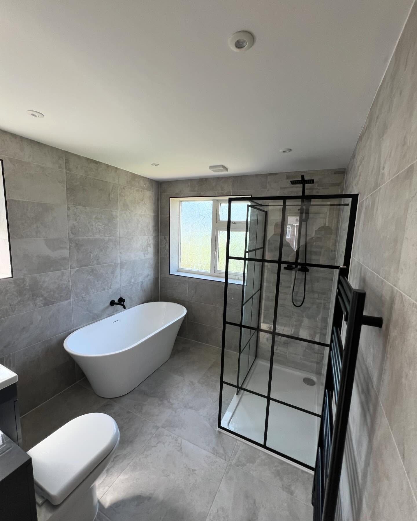 Refurbished bathroom with freestanding bath and walk-in shower enclosure